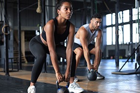 Couple lifting weights in exercise class
