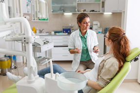 Dentist and patient talking in treatment room