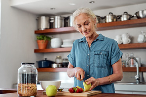 Woman cutting up fruit in kitchen